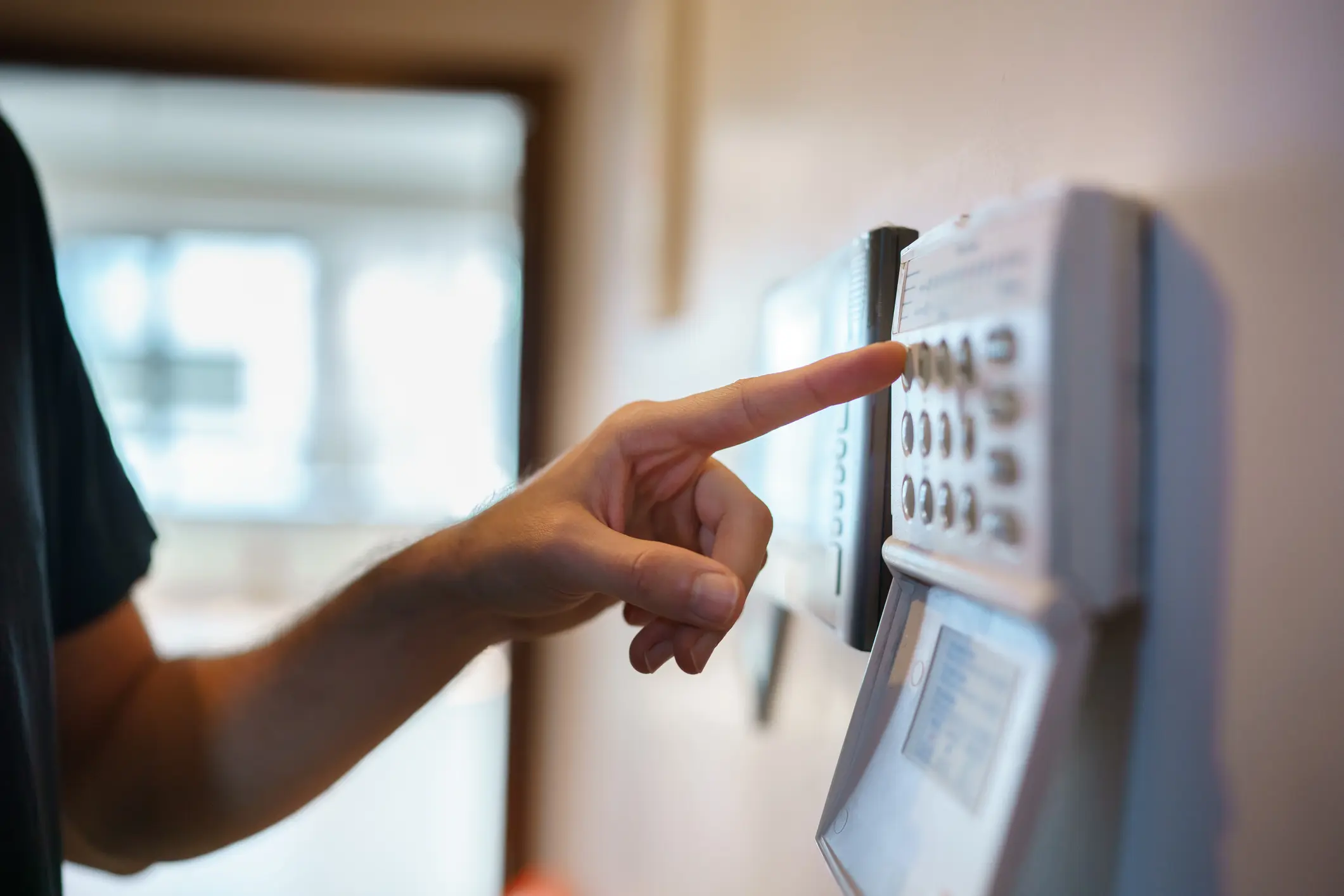 Hand entering code on home security keypad