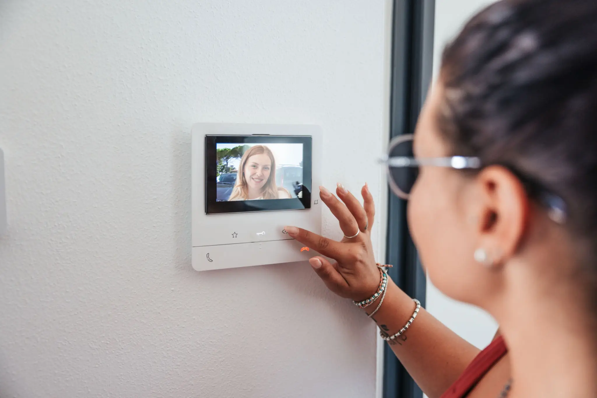Person using video intercom with screen display.